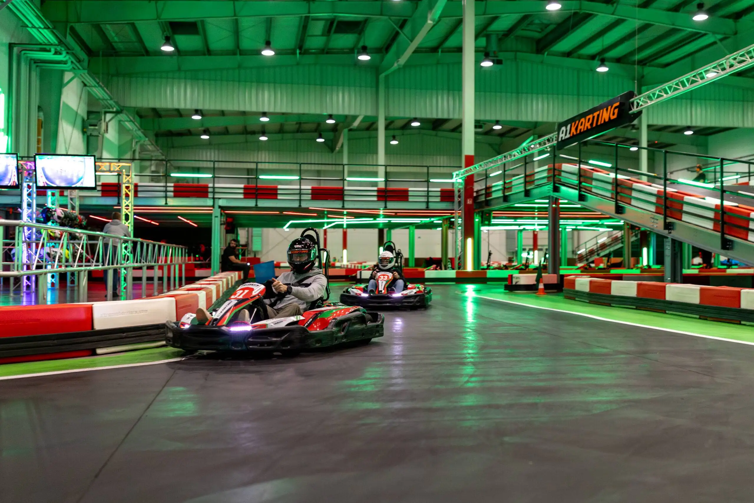 Grupa dorosłych kolegów w kaskach na dwupoziomowym torze kartingowym A1 Karting w Warszawie