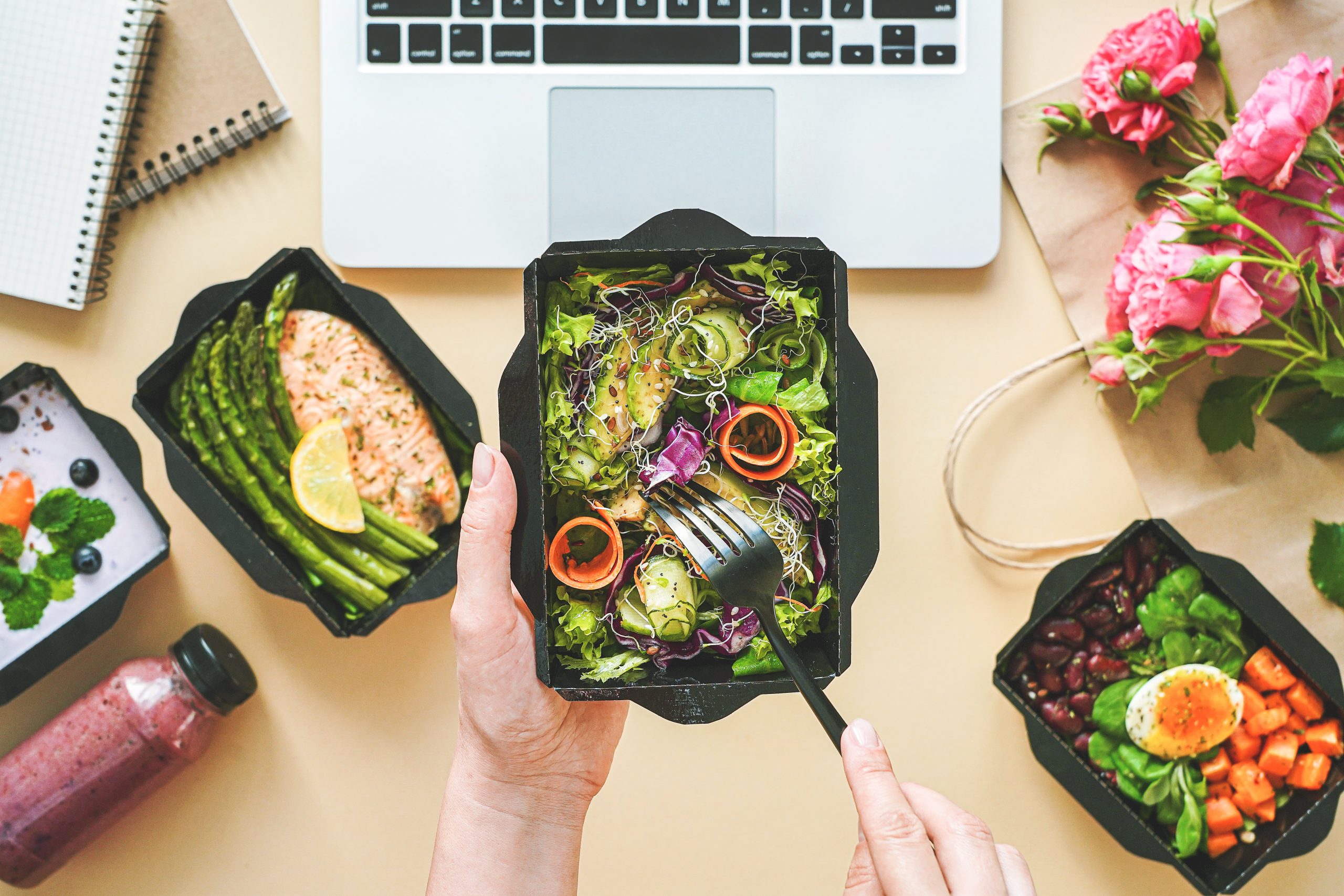 Gotowy lunch box do pracy z obiadem, pełnowartościowy posiłek na tle biurka. Dieta z dostawą od Zdrowo-Pojedzone